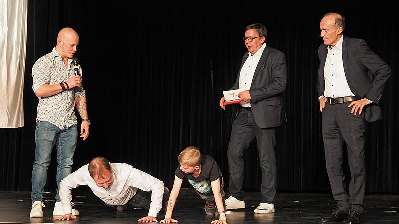 Moderator Thomas Apfel rief zur Liegest&uuml;tz-Challenge auf. Angeleitet von Felix Hamb&uuml;chen (links) und Eberhard Gienger waren zehn Liegest&uuml;tze von Jan Gorr (HSC 2000), Felix und Thomas Apfel zumachen.