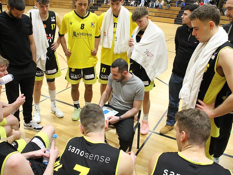 TSV-Headcoach Mark V&ouml;lkl (sitzend), Co-Trainer Daniel Schmidt (links) und das gesamte G&uuml;&szlig;bacher Team haben trotz des Halbfinal-Aus auch in dieser Saison geliefert und die 2022 begonnene Erfolgsserie fortgesetzt.