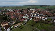 Ein Dorf im Fokus durch den Prozess gegen den Kopf von "Go&amp;Change": Hinter dem Turm der örtlichen Pfarrkirche in Lülsfeld (Lkr. Schweinfurt) ragt das große Gebäude des früheren Klosters "Maria Schnee" hervor.