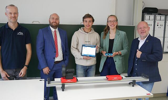 Unser Bild zeigt (von links) den Fachschaftsleiter für Physik, Florian Treisch, den Sparkassen-Beratungscenterleiter Felix Dorn, Schüler Dominik Freitag, Schülerin Letizia Albert und Direktor Markus Arneth hinter dem Versuchsaufbau mit den Smartca...