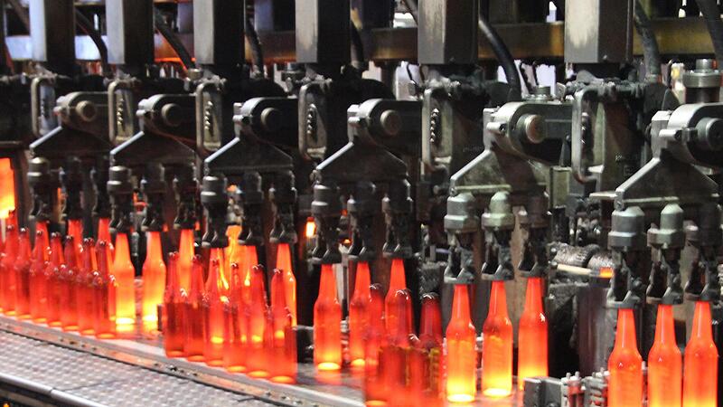 Wie ein pr&auml;zises Uhrwerk &ndash; die Glasautomaten formen aus Glastropfen Flasche um Flasche. Nun geht die Reise weiter Richtung K&uuml;hlbahn.