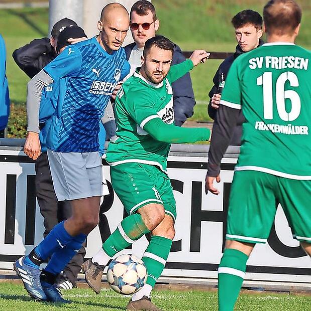 Unter Druck vom Rattelsdorfer Luca Krieglstein spielt Friesens Nicolai Altwasser (grün) den Ball zu Felix Müller. Bei diesem Punktspiel im November 2024 riss Altwasser sich die Achillessehne.