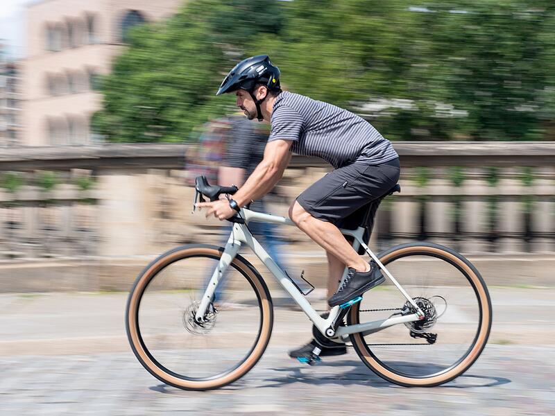 Mann f&auml;hrt mit einem Gravelbike  durch die Stadt