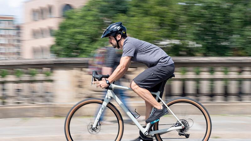 Mann fährt mit einem Gravelbike  durch die Stadt