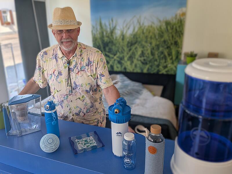 Friedrich Bayerlein Friedrich Bayerlein mit einer Auswahl der Produkte zur Wasserveredelung auf Keramikbasis. Das Snoezelen-Bett im Hintergrund wartet noch auf Wassermatratze und Sound.
