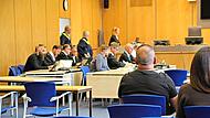 Vier der Angeklagten sitzen links. Der f&uuml;nfte Angeklagte sitzt rechts.Julia Scholl