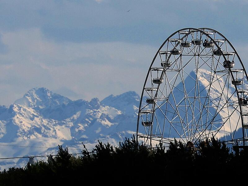 Riesenrad vor schneebedeckten Bergen