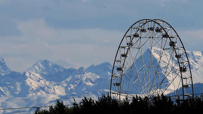 Riesenrad vor schneebedeckten Bergen
