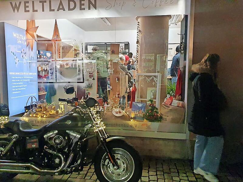 Blick ins Schaufenster des Weltladens am Lichterglanz mit Hungers Harley davor.