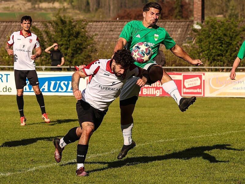 Der Kronacher Co-Trainer Sergen Koc (wei&szlig;es Trikot) geht zum Kopfball, aber Altan Y&uuml;r&uuml;k kann mit dem Fu&szlig; kl&auml;ren.