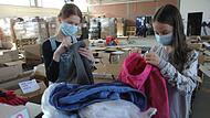 Lenja und Kim aus der 6f sortieren Kleidung für Geflüchtete aus der Ukraine.