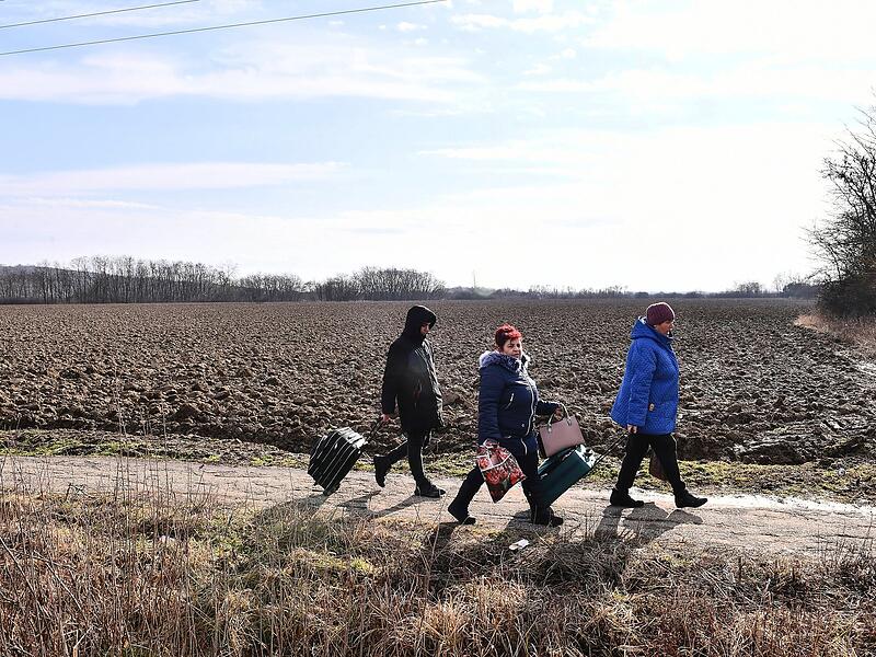 Aus der Ukraine flüchtende Menschen überqueren die ungarisch-ukrainische Grenze unweit des Ortes Barabas. Ungarn hat denjenigen, die vor russischen Angriffen fliehen, Schutz gewährt.