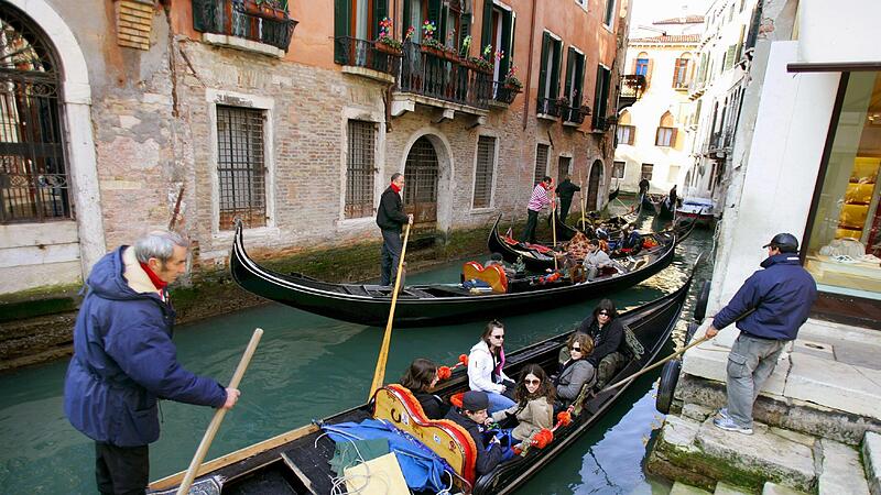 Touristen werden in Gondeln bei einer Stadtbesichtigung durch einen engen Seitenkanal in Venedig gefahren. F&uuml;r Taschendiebe sind solche Menschen beliebte Opfer &ndash; Monica Poli, bekannt als &bdquo;Lady Pickpocket&ldquo;, will die Besucher der Lagunenstadt davor ...