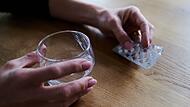 Frau h&auml;lt Tabletten in der Hand