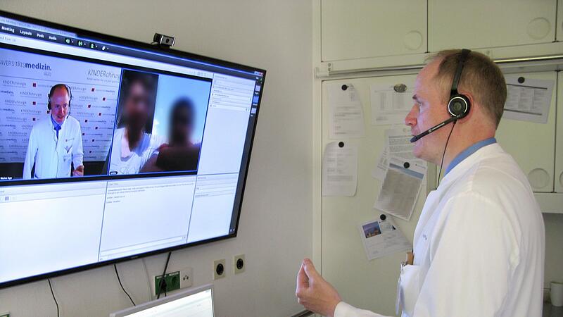 In einem Videoanruf bespricht  ein  Arzt mit seinen Patienten die Behandlung.