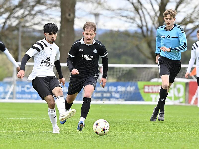 Mert K&ouml;se vom TSV M&ouml;nchr&ouml;den II und der Ebersdorfer Tim Oikonomides (schwarz) werden vom Schiedsrichter be&auml;ugt.