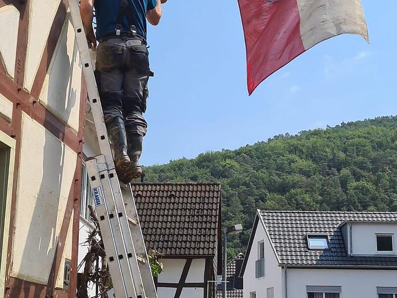 „Ein Zeichen, dass wir nicht aufgeben“: Uwe Jakobs hisst die Ahrweiler Flagge.