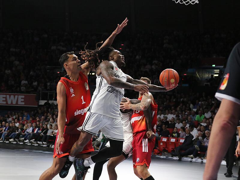 Cobe Williams (in weiß) war zwar Bamberger Topscorer beim Spiel in München, aber hatte einen schweren Stand in Korbnähe.