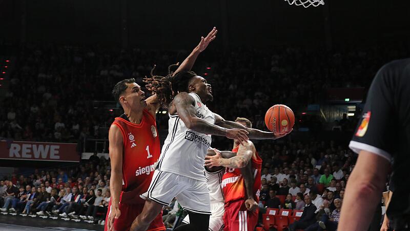 Cobe Williams (in weiß) war zwar Bamberger Topscorer beim Spiel in München, aber hatte einen schweren Stand in Korbnähe.