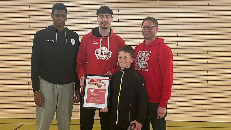 Elijah Ndi und Julius B&ouml;hmer von den W&uuml;rzburger Baskets zusammen mit dem Gewinner Marlon Kess und dem Vorsitzenden des AWO Kreisverbandes Gerald M&ouml;hrlein bei der Preis&uuml;bergabe.