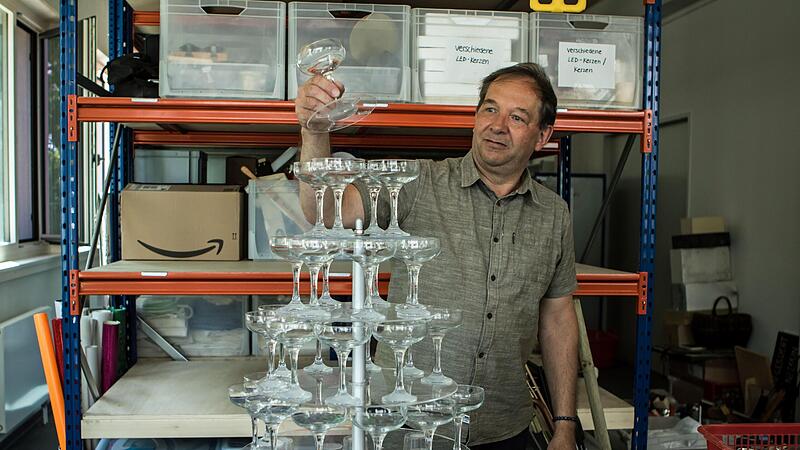 Eine Eigenkonstruktion der Requisite war diese mehrstöckige Sektglas-Pyramide für „Lucia di Lammermoor“. Manfred Dehler demonstriert das Besondere dieser Requisite: einzelne Gläser konnten entnommen werden, ohne die Statik zu gefährden.