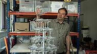 Eine Eigenkonstruktion der Requisite war diese mehrstöckige Sektglas-Pyramide für „Lucia di Lammermoor“. Manfred Dehler demonstriert das Besondere dieser Requisite: einzelne Gläser konnten entnommen werden, ohne die Statik zu gefährden.