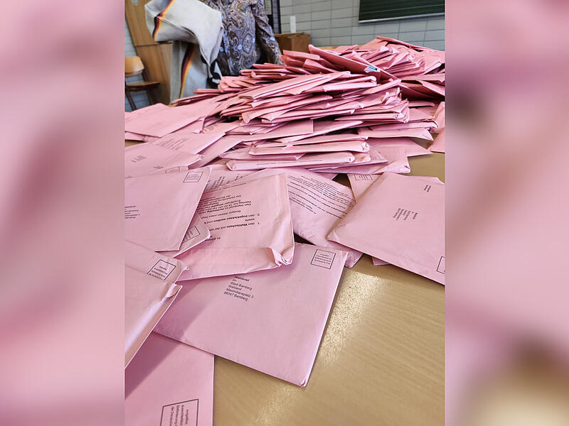 Wie Wahlhelfer bei der Europawahl 2024 in Bamberg die Demokratie wahren Die Wahlhelferinnen und -helfer zählen auch die pinken Briefwahlumschläge aus.