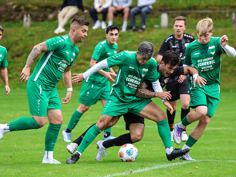 Kronachs Angreifer Philipp Schubert  (schwarz) alleine gegen die versammelte Stockheimer Abwehr – letztlich kann Stockheims Spielertrainer Alper Yürük zusammen mit Jamie Martin (grün, von links) den Angriff von Schubert stoppen.