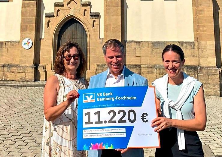 Scheck&uuml;bergabe vor der Pfarrkirche St. Sebastian in Hallerndorf (v.&nbsp;l.): Kirchenpflegerin Anita Volkmuth, Pfarrer Matthias Steffel und Filialleiterin Karin Kropfelder. Gerhard Volkmuth