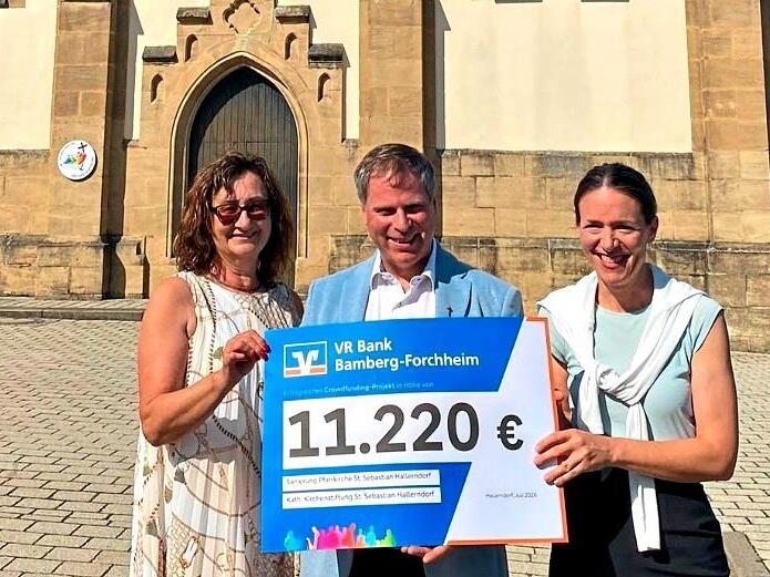 Scheck&uuml;bergabe vor der Pfarrkirche St. Sebastian in Hallerndorf (v.&nbsp;l.): Kirchenpflegerin Anita Volkmuth, Pfarrer Matthias Steffel und Filialleiterin Karin Kropfelder. Gerhard Volkmuth