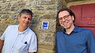 Dr. Gerrit Himmelsbach (links) vom Spessartprojekt und der Münnerstädter Kulturmanager Dr. Nicolas Zenzen haben die Erarbeitung des Münnerstädter Kulturweges – im Bild auch zu sehen der Wanderwegweiser – wissenschaftlich und organisatorisch beglei... Dr. Gerrit Himmelsbach (links) vom Spessartprojekt und der Münnerstädter Kulturmanager Dr. Nicolas Zenzen haben die Erarbeitung des Münnerstädter Kulturweges – im Bild auch zu sehen der Wanderwegweiser – wissenschaftlich und organisatorisch beglei...