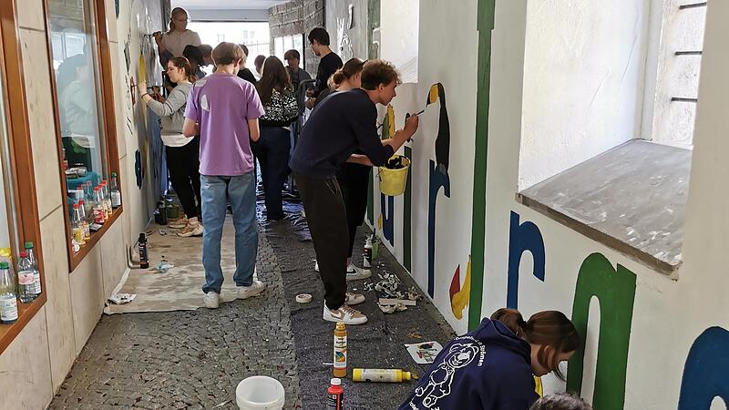 Kunstklasse der Eltmanner Realschule bemalt Fußgängerpassage zum Weltladen mit Fair-Trade-Symbolen