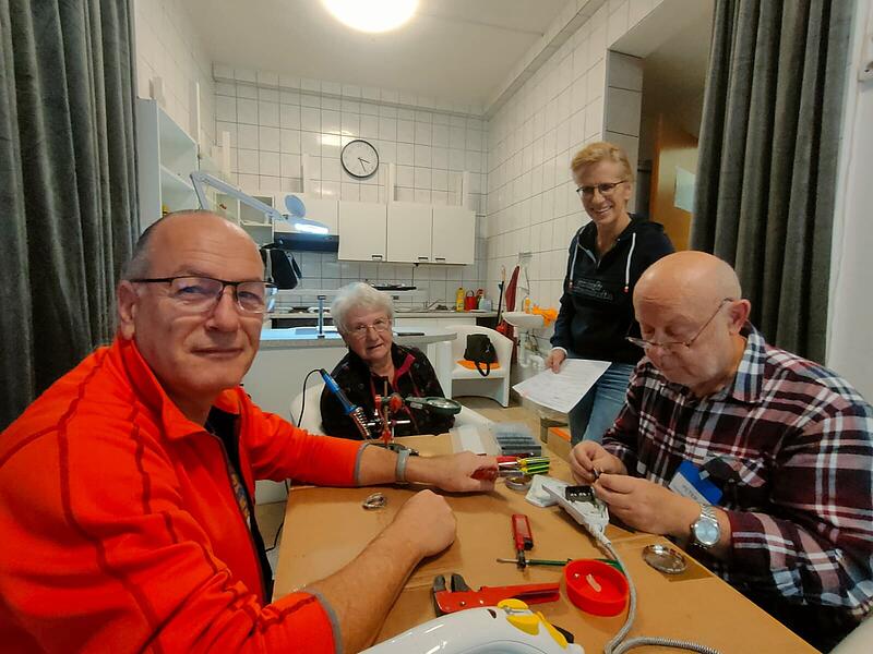 Von links: Thiemo Schroll, Kundin Annette Wolf. Anja Schneider und Peter Lorenz reparieren gemeinsam ein Bügeleisen.