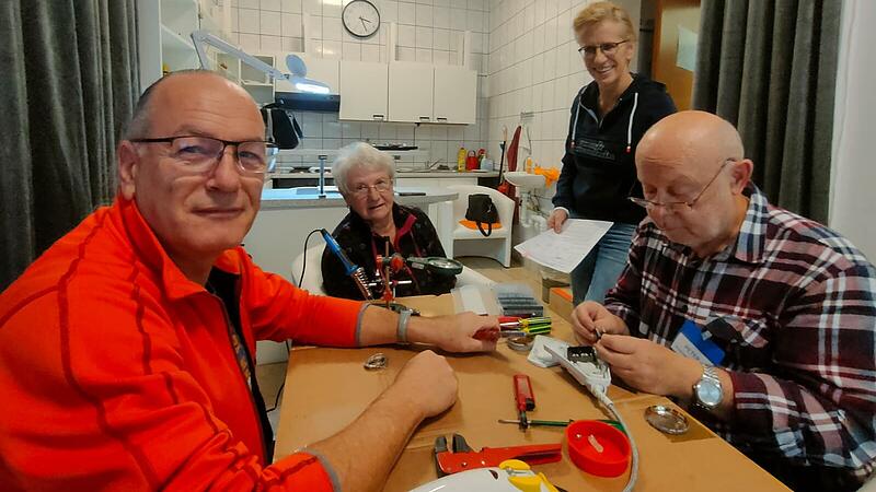 Von links: Thiemo Schroll, Kundin Annette Wolf. Anja Schneider und Peter Lorenz reparieren gemeinsam ein B&uuml;geleisen.