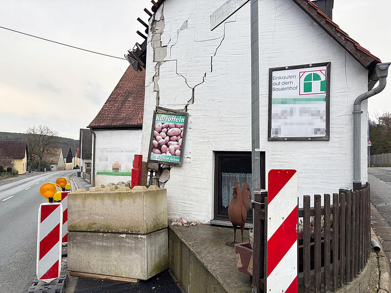 Die Ecke des Gebäudes, in das am Montag der Lkw geprallt ist, weist große Risse auf. Massive Betonelemente stützen die Mauer, der Gehweg ist an dieser Stelle gesperrt.