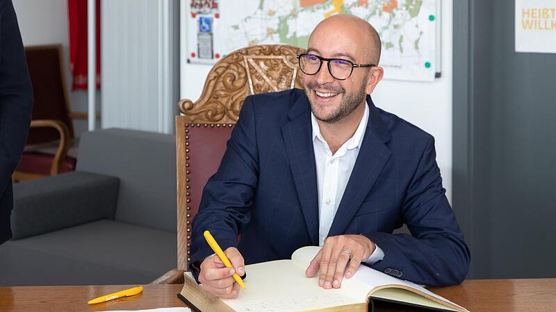 Anthony Descloziers, Bürgermeister der Partnerstadt Sainte-Luce-sur-Loire, trägt sich in das Goldene Buch der Stadt Herzogenaurach ein.