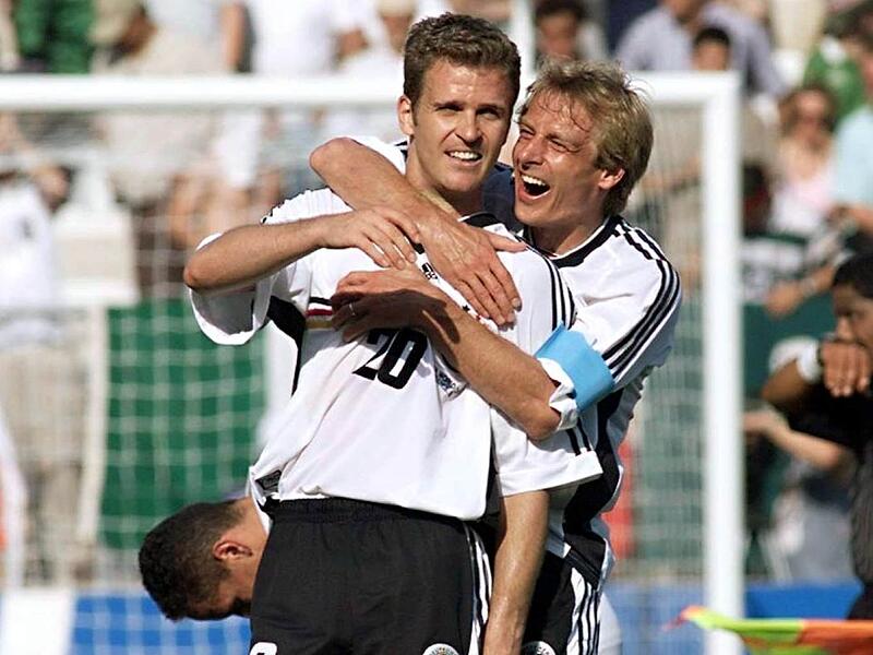 WM 1998: J&uuml;rgen Klinsmann und Oliver Bierhof im wei&szlig;en Trikot mit schwarz-rot-goldenen Querstreifen auf H&ouml;he der Nummer.
