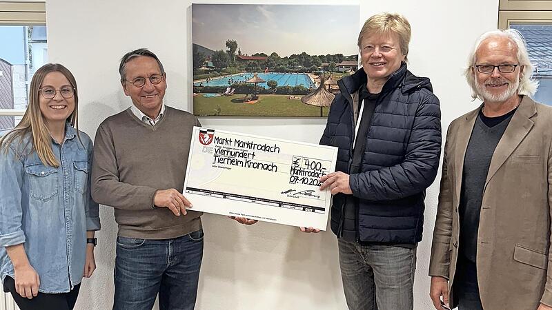 Vanessa Meyer, B&uuml;rgermeister Norbert Gr&auml;bner, Vorsitzender Klaus Barnickel und Bademeister Markus Holzmann (v. l.) bei der Scheck&uuml;bergabe.