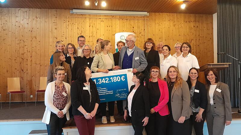 Die Staatsministerin f&uuml;r Gesundheit, Pflege und Pr&auml;vention Judith Gerlach (Mitte) &uuml;bergibt dem Team hinter &bdquo;Care im Quartier&ldquo; eine F&ouml;rdertafel im Wert von 1.342.180 Euro.