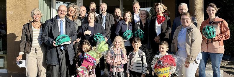 Unser Bild zeigt Oberbürgermeister Dirk Vogel mit einigen Abc-Schützen und ihren Lehrerinnen sowie einem Teil der insgesamt 15 Sponsoren bei der Übergabe der Fahrradhelme an der Henneberg-Grundschule in Garitz.