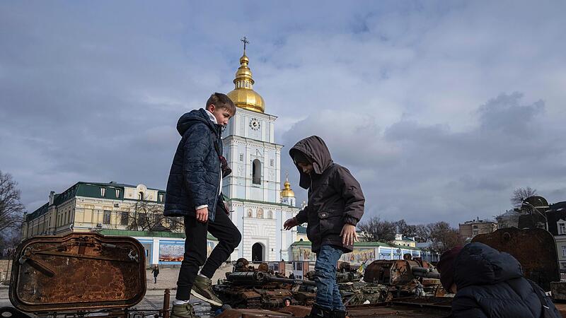 Kinder stehen auf einem zerst&ouml;rten russischen Fahrzeug im Stadtzentrum von Kiew.