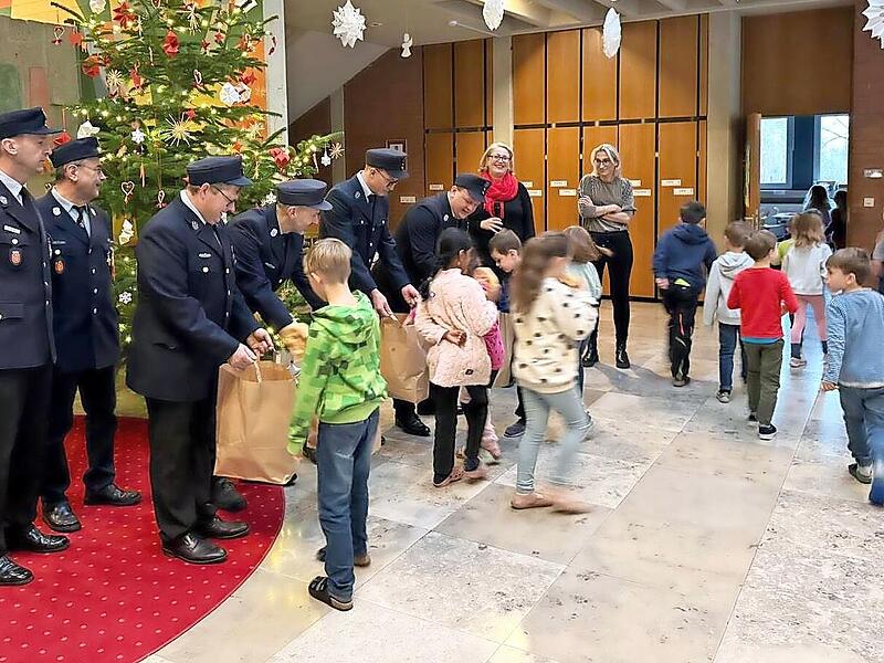 Die uniformierten Feuerwehrleute aus Oberehrenbach bringen Brezen f&uuml;r das Schulfr&uuml;hst&uuml;ck mit.