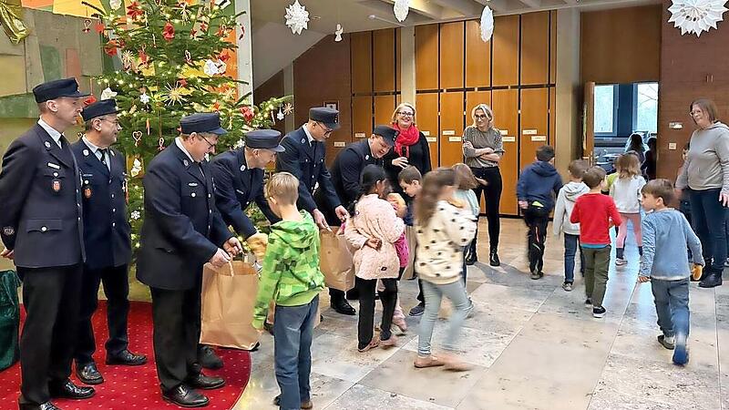 Die uniformierten Feuerwehrleute aus Oberehrenbach bringen Brezen f&uuml;r das Schulfr&uuml;hst&uuml;ck mit.