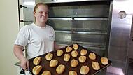 Goldgelb und kross, wie es die Kunden in Pfarrweisach kennen. Nadine Eisfelder, die neue Chefin der Backstube, holt Br&ouml;tchen aus dem Ofen.