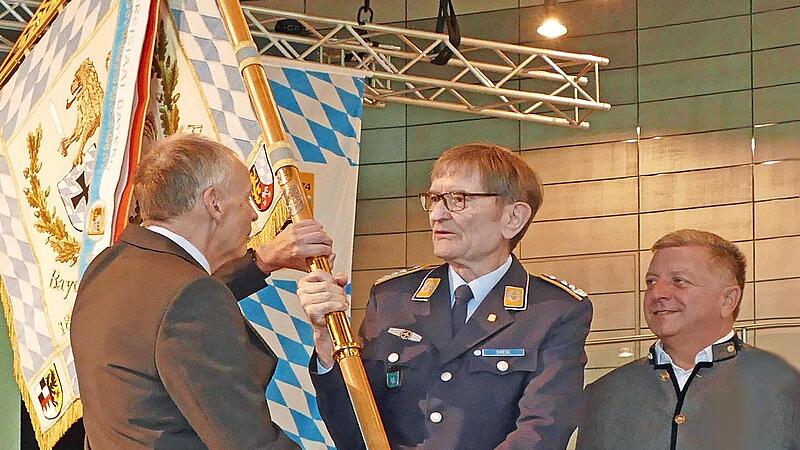 Aus der Hand von Oberst a.D. Richard Drexl (Mitte) erhält Generalmajor a.D. Norbert Wagner (links) die Standarte des BSB, Staatsminister Christian Bernreiter (rechts) gratuliert.