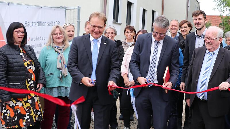 B&uuml;rgermeister Bernd Rebhan (v. l.) und Pfarrer Jochen Pickel (v. M.) durchschnitten das Band zur Er&ouml;ffnung der neuen Kindertagesst&auml;tte.