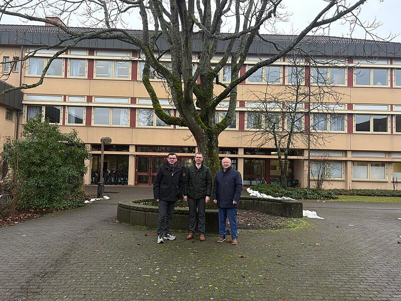 B&uuml;rgermeister Armin Warmuth (von links), Stiftungsvorstand der Carl von He&szlig; Sozialstiftung Marco Sch&auml;fer sowie Landrat und Stiftungsratsvorsitzender Thomas Bold stehen vor dem Gymnasium in Hammelburg.