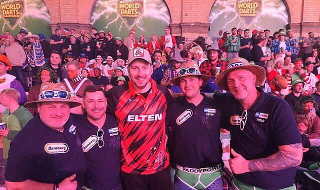 Darts-WM Die BMI Vedag Dachpappen Darter aus Bamberg beim WM-Auftakt im Ally Pally mit Darts-Profi Florian Hempel (M.), von links: Klaus Schunk, Ronald List, Kevin Martin und Thilo Reinhart