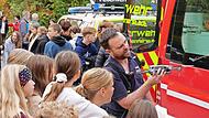 Ein Mitglied der Feuerwehr Münnerstadt demonstriert Schülern die Funktionsweise einer Drohne.