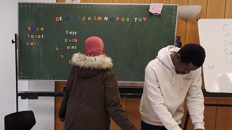 Mit Hilfe von Magnetbuchstaben erarbeiten sich Geflüchtete das Alphabet und die ersten Wörter in einer für sie fremden Sprache.